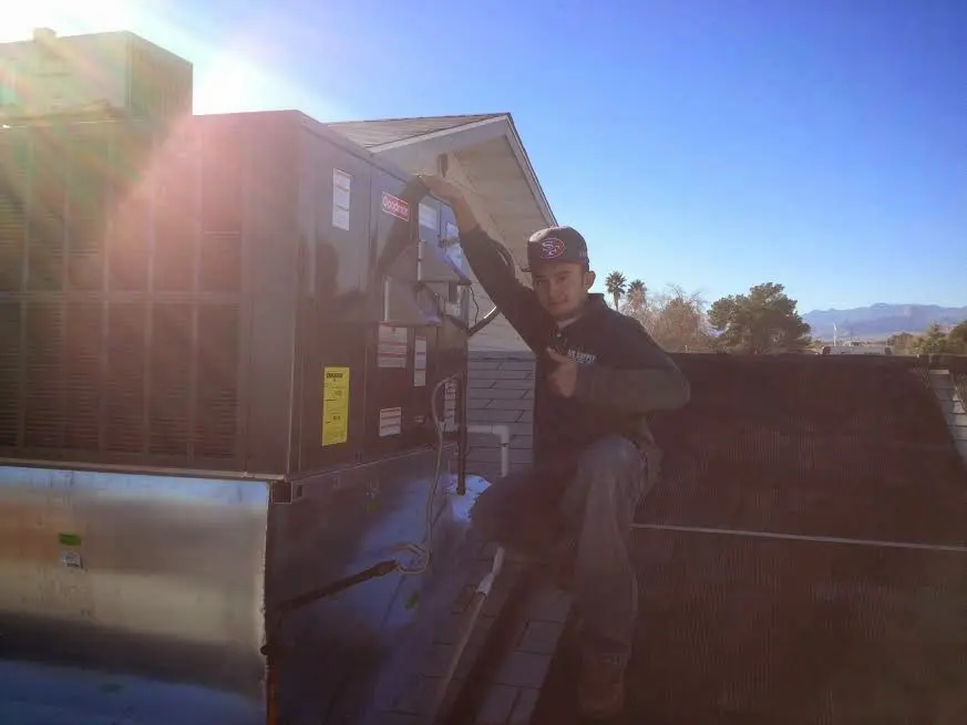 HVAC technician performing Air Duct Repair on a rooftop unit in Richmond